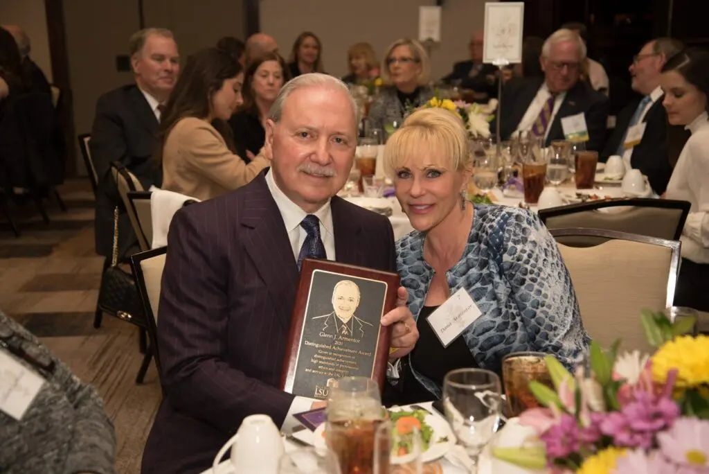 Glenn Armentor holding an award at a community banquet
